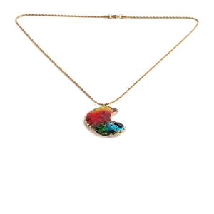 Detail of gold twisted rope chain with a multicolor crystal crescent moon pendant