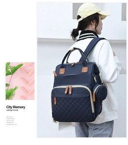 Detail view of large capacity navy blue quilted diaper backpack with gold zipper hardware