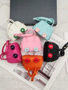 Mini car wheel coin purses in six colors on a plush surface with gold-tone hardware