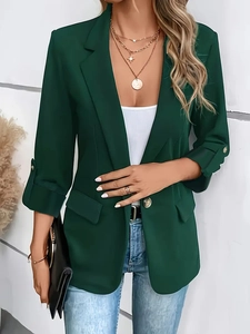 Detailed shot of dark green blazer with gold buttons and single-breasted closure