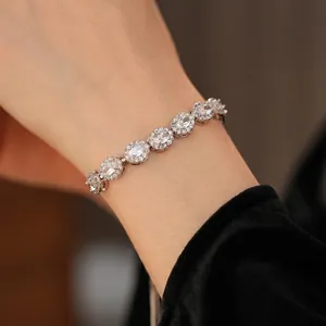 Bracelet vintage avec zircons ovales et halo de diamants sur poignet féminin en argent