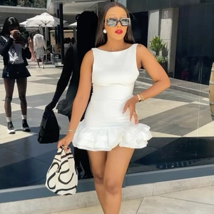 Detail of white sleeveless mini dress with layered ruffles and slim fit design