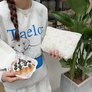 Detailed texture of quilted floral cotton fabric on the compact cosmetic pouch
