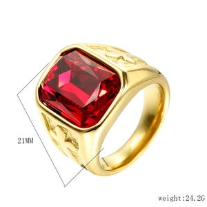 Detailed view of men's gold stainless steel ring with a large red gemstone and carvings