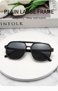 Detailed close-up of oversized black double bridge sunglasses on a modern marble setting