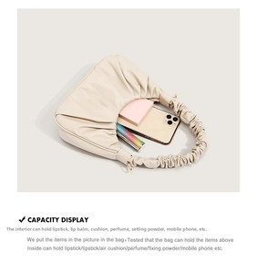 Internal capacity of the cream pleated cloud bag showing phone and cosmetics