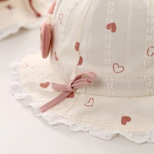 Sweet baby sun hat with pink hearts, lace trim and bow on breathable cream cotton fabric