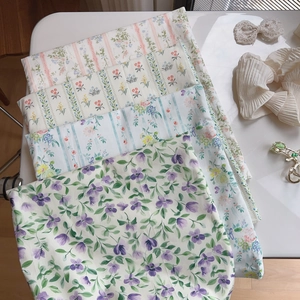 Dettaglio di tessuti in cotone con stampa floreale blu e viola per borse a tracolla