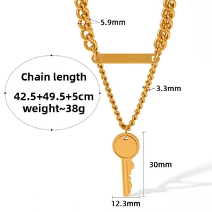 Macro shot of gold double layer chain necklace with key pendant and rectangle plaque detail