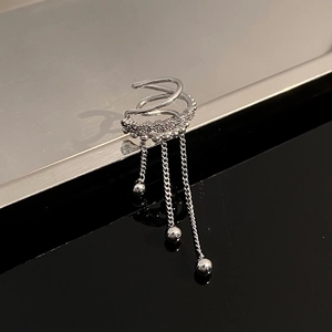 Detailed view of silver cuff earring with zircon bands and triple long chain tassels
