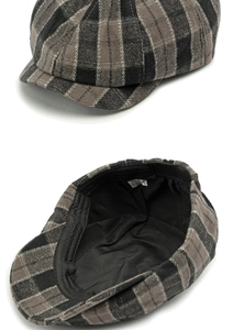 Detail view of cotton newsboy cap showing grey plaid pattern and black inner lining