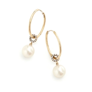 Detail of silver hoop earrings featuring sparkling tassels and elegant white pearls