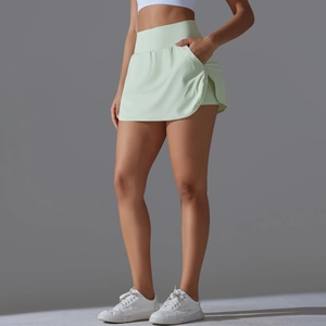 Detail view of mint green high-waisted tennis skort showing the built-in side phone pocket
