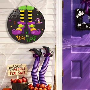 Halloween Trick or Treat door sign featuring witch legs and bats on a white wall