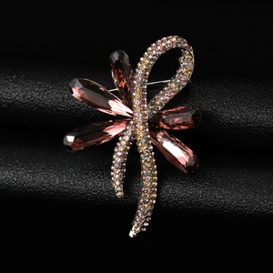 Detailed shot of pink crystal bow brooch with colorful rhinestones on black leather
