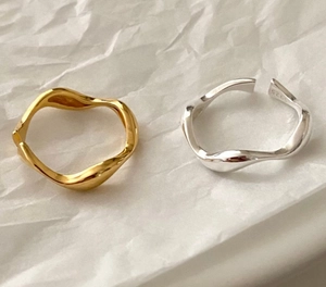 Detailed view of silver and gold irregular wave rings with S925 hallmark engraving