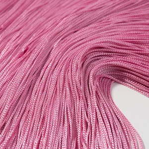 Close-up of pink fringe trim showing smooth synthetic fiber texture and fine weaving details