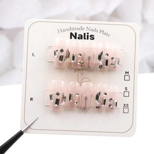 Gros plan d'ongles faits main avec dégradé rose et détails pailletés argentés