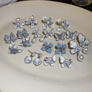 Detail of crystal butterfly and pearl earrings in silver and pale blue finish
