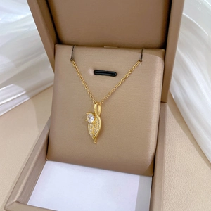 Luxurious gold leaf pendant necklace with crystals on silk fabric in jewelry box