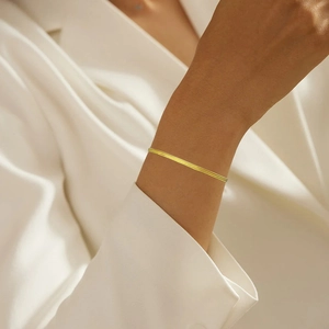 Close-up of elegant double-layered flat snake chain bracelet in bright gold finish