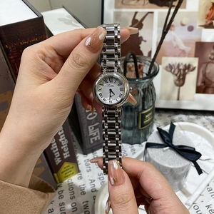 Détail d'une montre vintage argentée pour femme avec chiffres romains et bracelet acier