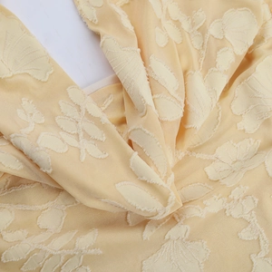 Vista macro del tessuto jacquard giallo chiaro con dettagli floreali testurizzati