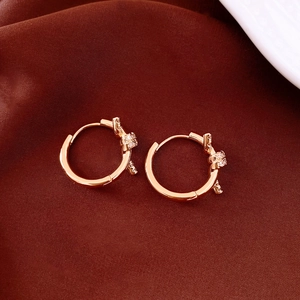 Close-up of 18k rose gold plated knot earrings with sparkling cubic zirconia on silk