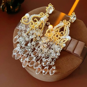 Detail of vintage chandelier earrings with crystal glass tassels and pearls on box