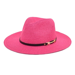 Detail of magenta woven straw fedora featuring a slim black leather band and gold buckle
