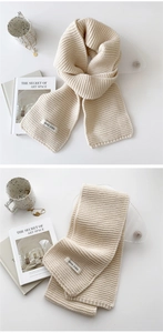 Detail shot of beige and khaki knitted scarves with woven texture and logo label