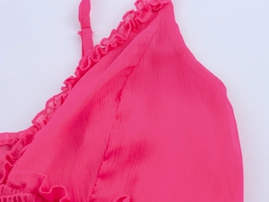 Détail de robe en mousseline rose vif avec bords à volants et texture plissée
