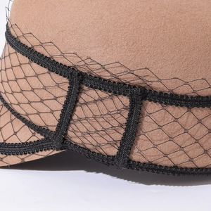 Detailed close-up of wool felt newsboy hat with elegant black mesh veil and woven trim