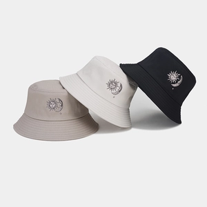 Dettaglio di cappelli bucket in cotone con ricamo sole e luna in tre colori diversi