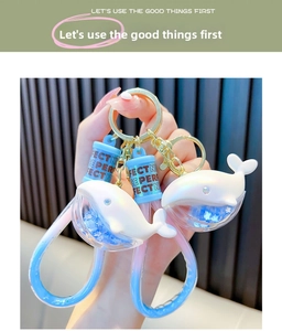 Detail of dolphin liquid glitter keychain with blue gradient and star sequins charm