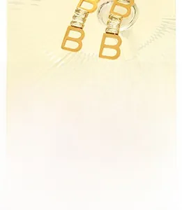 Detail view of gold-plated double B earrings with clear rectangular zircon stones