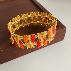 Macro detail of vintage gold plated bracelet with orange enamel and yellow crystals