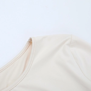 Vue détaillée du haut beige ajusté montrant le col rond et la finition à double couture