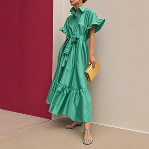 Détail de robe longue verte avec manches à volants et ceinture à nouer assortie