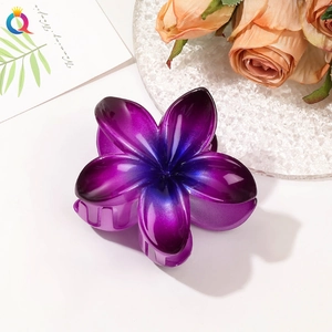 Detailed close-up of a flower hair claw clip with purple gradient and glossy finish