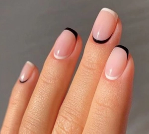 Macro view of medium square press-on nails with white French tips and black base line detail