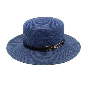 Close-up of a navy straw boater hat with fine weaving and gold buckle detail