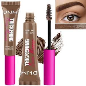 Detail showing brown brow mascara wand with hair-like fibers and creamy texture display