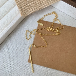 Close-up of minimalist gold-plated 925 silver link chain necklace on textured fabric