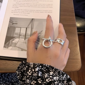 Minimalist silver chain and open circle ring set shown in a lifestyle desk setting