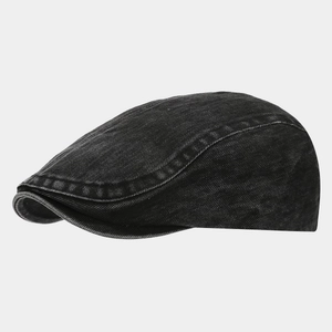 Detailed view of washed black denim texture and neat stitching on a vintage flat cap