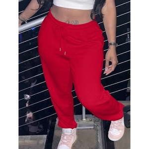 Detail of red joggers featuring elastic drawstring waist and cuffed ankles for women