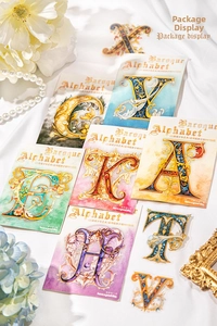 Close-up of Baroque Alphabet PET stickers featuring ornate gold patterns on white silk background