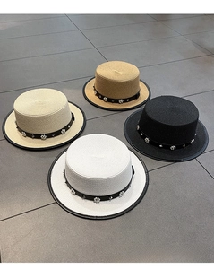 Detail of four elegant straw boater hats in beige khaki black and white with floral studs