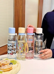 Detail of four colorful cartoon plastic straw bottles with portable carrying straps